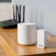Mesh wifi node and wifi extender side by side, illustrating mesh wifi vs extender comparison for fixing home dead zones