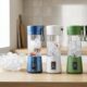 Several of the best portable blenders lined up on a counter crushing ice for smoothies