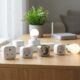 Three of the best smart plugs 2026 models plugged into a wall outlet with an energy monitoring app on a smartphone