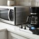 Plug-in power meter measuring appliance energy vampire standby drain on a kitchen counter