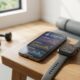 Smartphone running one of the best AI fitness coaching apps next to a smartwatch in a home gym