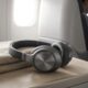 Over-ear noise-cancelling headphones for flights resting on an airplane tray table near a window seat