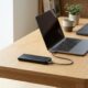 Portable power banks for laptops charging a MacBook Pro via USB-C cable on a desk