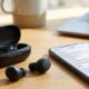 Wireless earbuds and charging case on a desk, illustrating why bluetooth earbuds keep disconnecting