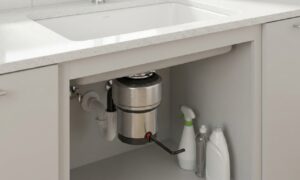 Garbage disposal humming not working being reset with an Allen wrench under a kitchen sink